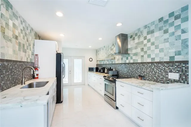 a kitchen with white cabinets and stainless steel appliances