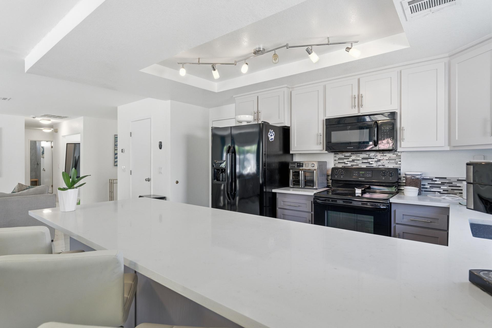 67220 Quijo Road Cathedral City, CA 92234 - Photo 5 of 26 a kitchen with stainless steel appliances granite countertop a refrigerator stove microwave and sink