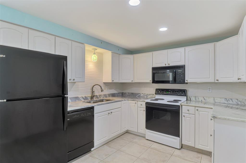 2490 Eleventh Street Englewood, FL 34224 - Photo 17 of 49 a kitchen with a white stove top oven and refrigerator