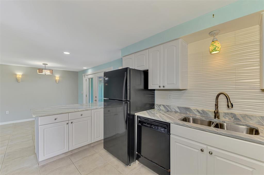 2490 Eleventh Street Englewood, FL 34224 - Photo 19 of 49 a kitchen with a sink refrigerator and cabinets