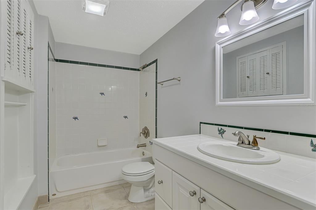 2490 Eleventh Street Englewood, FL 34224 - Photo 28 of 49 a bathroom with a granite countertop sink toilet a mirror and shower