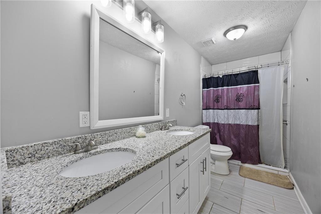 505 Stone Road McDonough, GA 30253 - Photo 19 of 28 a bathroom with a granite countertop sink and a mirror