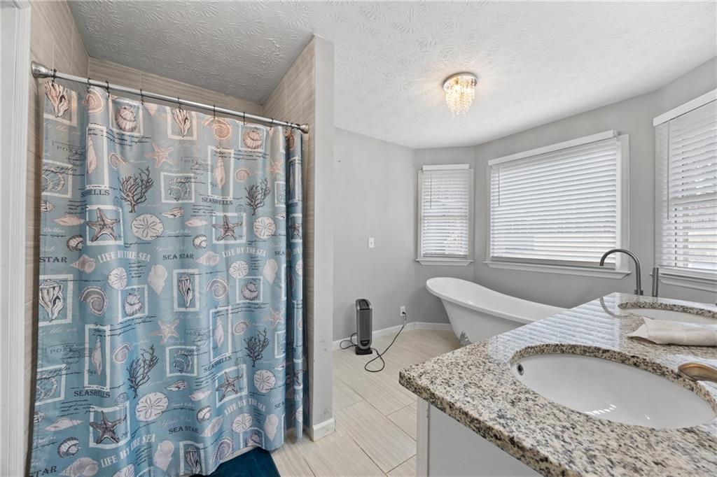 505 Stone Road McDonough, GA 30253 - Photo 26 of 28 a bathroom with a granite countertop sink a mirror and a shower
