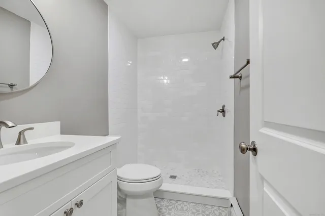 a bathroom with a sink a toilet and shower