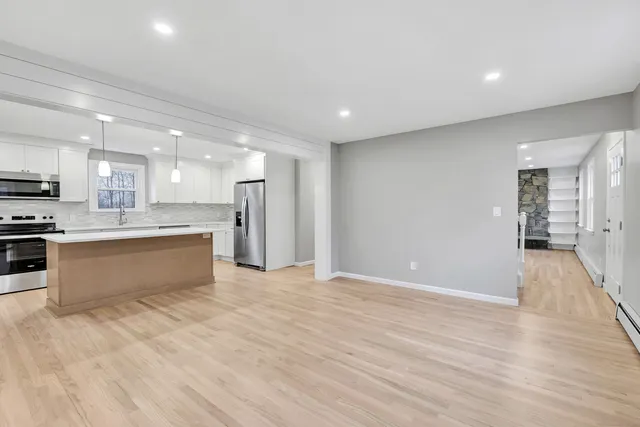 a large kitchen with stainless steel appliances granite countertop a stove a sink and a refrigerator