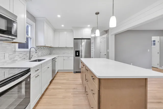 a kitchen with kitchen island a sink stainless steel appliances and cabinets