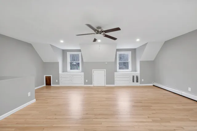 a view of a livingroom with a ceiling fan window and wooden floor