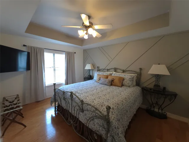 a bedroom with a bed and wooden floor