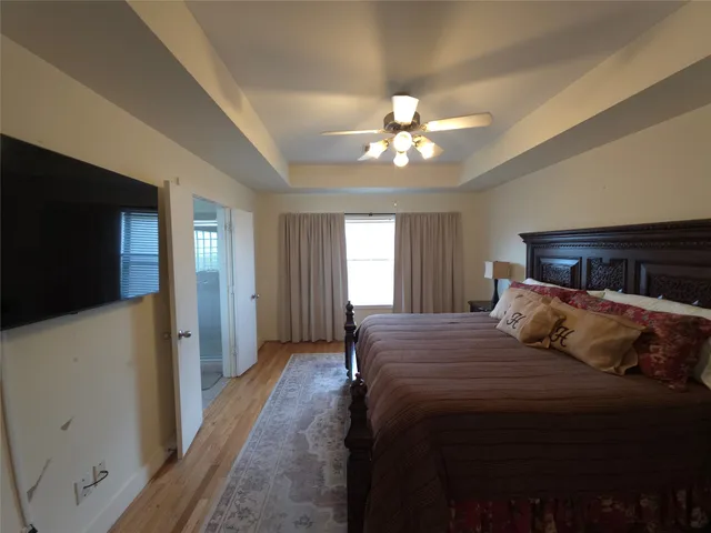 a bedroom with a large bed and a chandelier