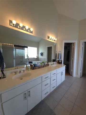a bathroom with a sink double vanity granite and a large mirror