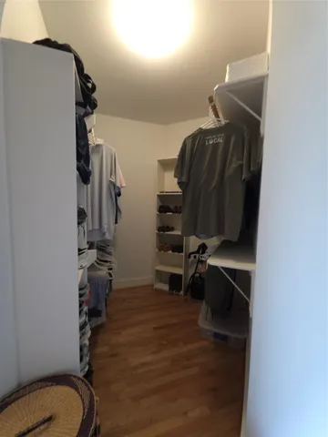 a view of walk in closet with clothes and shoes