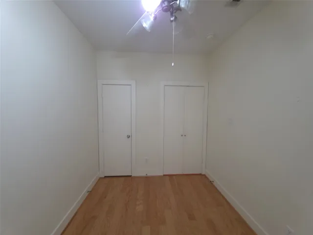a view of an empty room with a chandelier fan