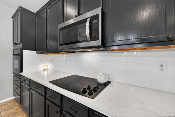 a kitchen with stainless steel appliances a cabinets and a stove top oven