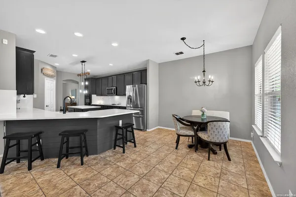 a kitchen with a dining table chairs and white cabinets