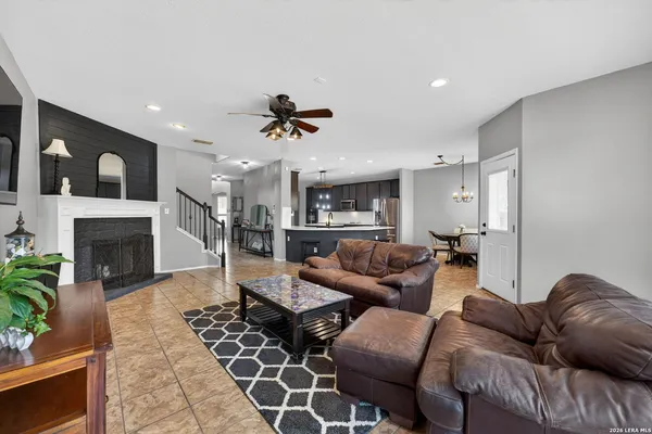 a living room with furniture a fireplace and a dining table with wooden floor