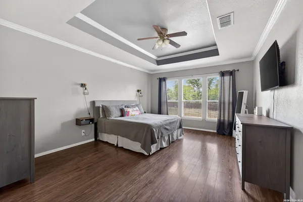 a spacious bedroom with a bed and a flat screen tv