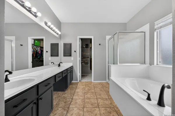 a spacious bathroom with a tub sink shower and mirror