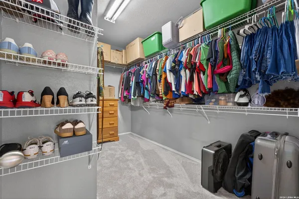a view of walk in closet with clothes and shoes