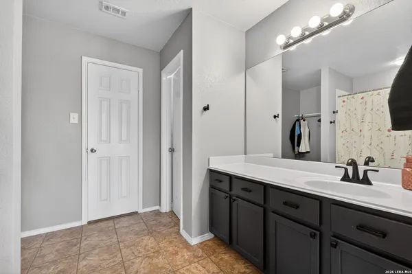a spacious bathroom with a double vanity sink mirror and shower