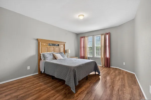 a bed sitting in a spacious bedroom next to a window