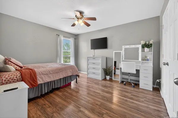 a spacious bedroom with a bed and a flat screen tv