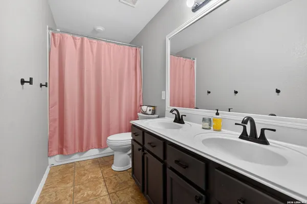 a bathroom with a double vanity sink toilet and a mirror