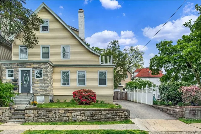 a front view of a house with a yard and potted plants