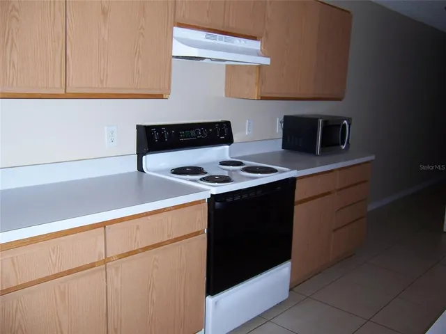 a kitchen with cabinets and a stove top oven