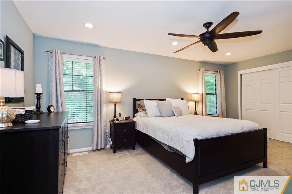 2406 Timber Oaks Road, Unit 2406 Edison, NJ 08820 - Photo 15 of 24 a bedroom with a bed and a chandelier
