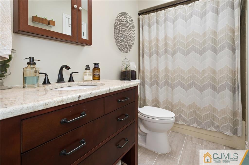 2406 Timber Oaks Road, Unit 2406 Edison, NJ 08820 - Photo 18 of 24 a bathroom with a granite countertop toilet sink and mirror