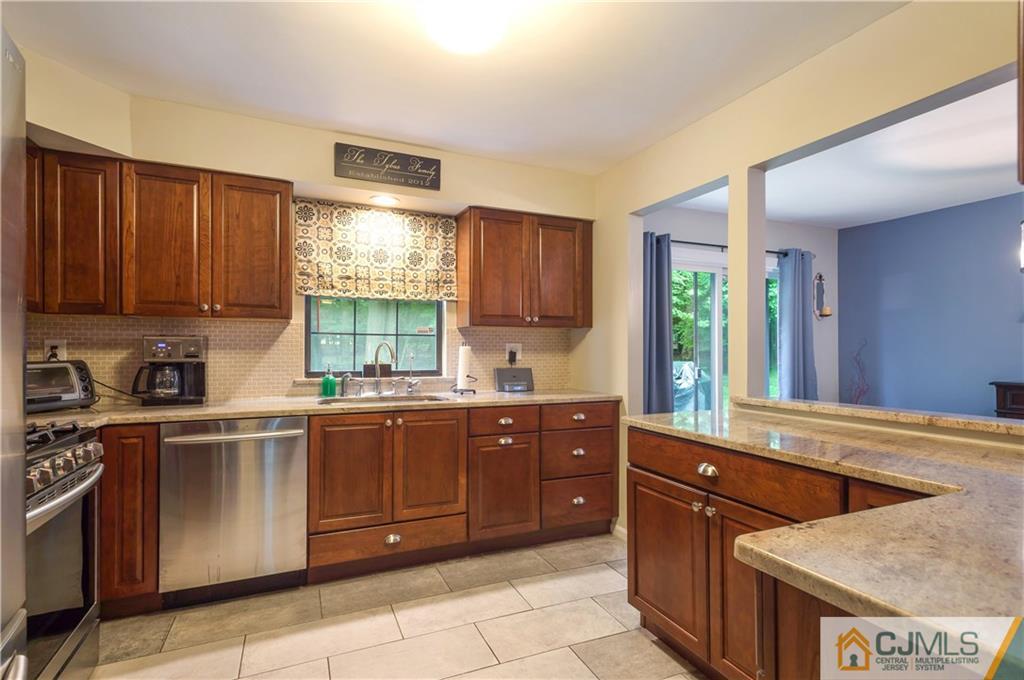 2406 Timber Oaks Road, Unit 2406 Edison, NJ 08820 - Photo 4 of 24 a kitchen with stainless steel appliances granite countertop wooden cabinets a stove a sink and a window