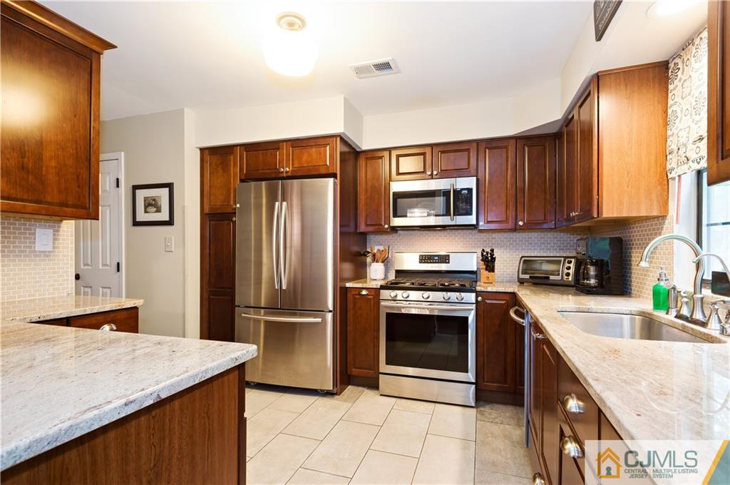 2406 Timber Oaks Road, Unit 2406 Edison, NJ 08820 - Photo 6 of 24 a kitchen with stainless steel appliances granite countertop a refrigerator stove microwave and sink