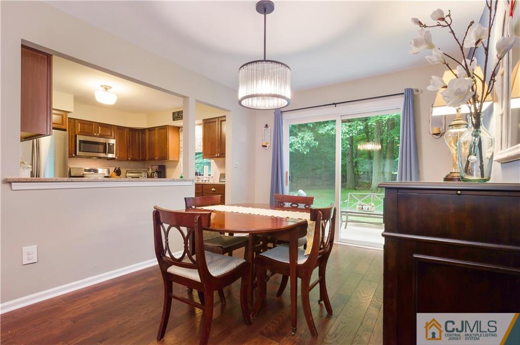 2406 Timber Oaks Road, Unit 2406 Edison, NJ 08820 - Photo 7 of 24 a dining room with furniture a chandelier and wooden floor