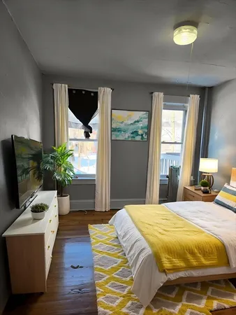 a bedroom with a bed and a potted plant