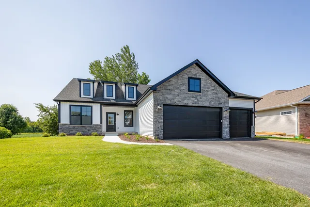 a front view of a house with a yard and garage