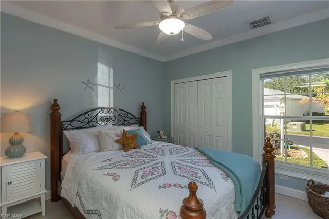 a bedroom with a bed and a lamp on dresser