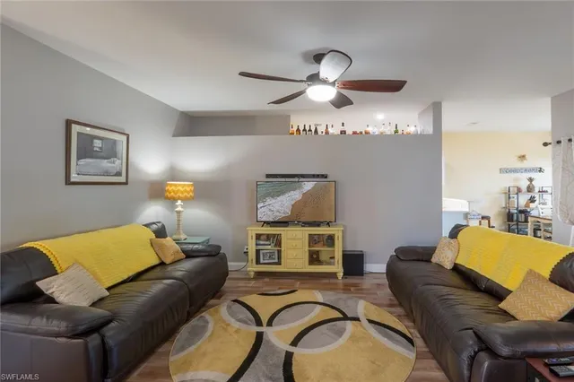 a living room with furniture and a ceiling fan