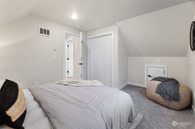 a bedroom with a bed and a painting on the wall