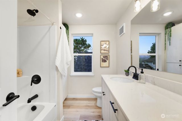 a bathroom with a tub sink and mirror