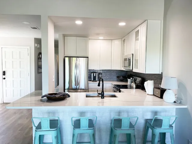 a kitchen with kitchen island granite countertop a sink and cabinets