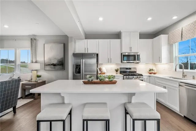 a kitchen with stainless steel appliances a stove a sink a microwave a refrigerator and cabinets