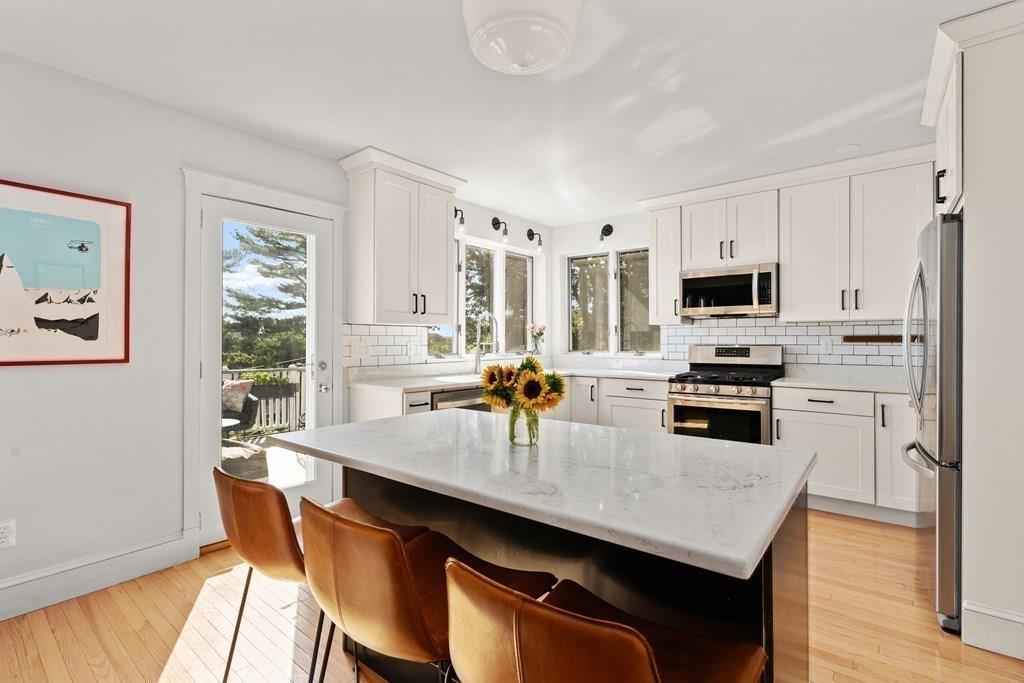 24 Cedarwood Road Boston, MA 02130 - Photo 6 of 18 a kitchen with stainless steel appliances a kitchen island hardwood floor sink stove dining table and chairs