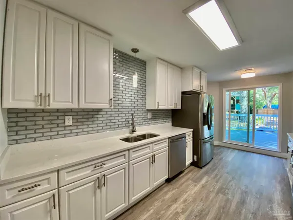 a kitchen with a sink cabinets stainless steel appliances and a window
