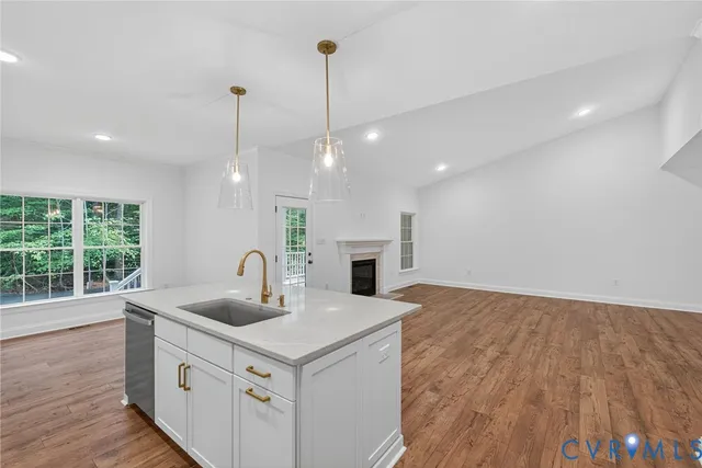 a kitchen with a sink a large window and a wooden floor