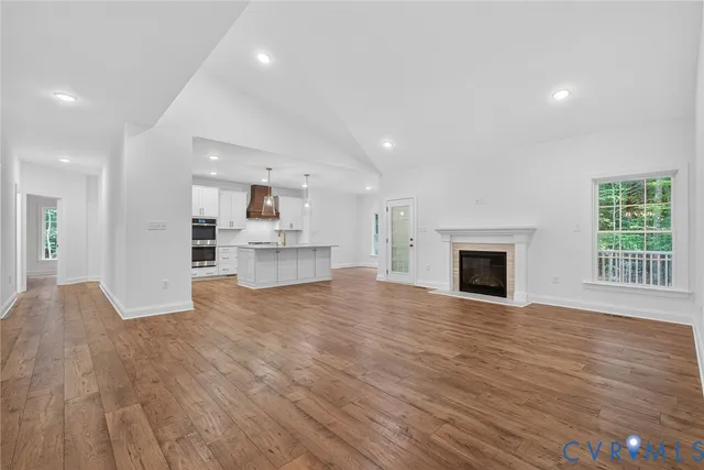 a view of empty room with wooden floor and fireplace