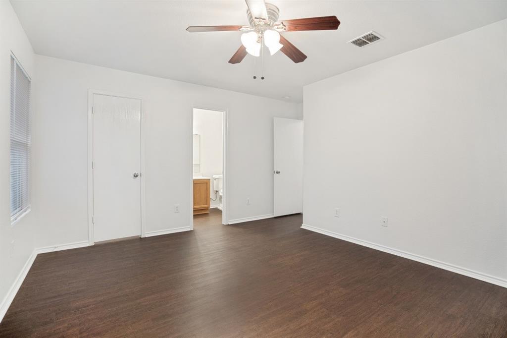 16701 Windthorst Way Fort Worth, TX 76247 - Photo 11 of 12 an empty room with wooden floor ceiling fan and windows