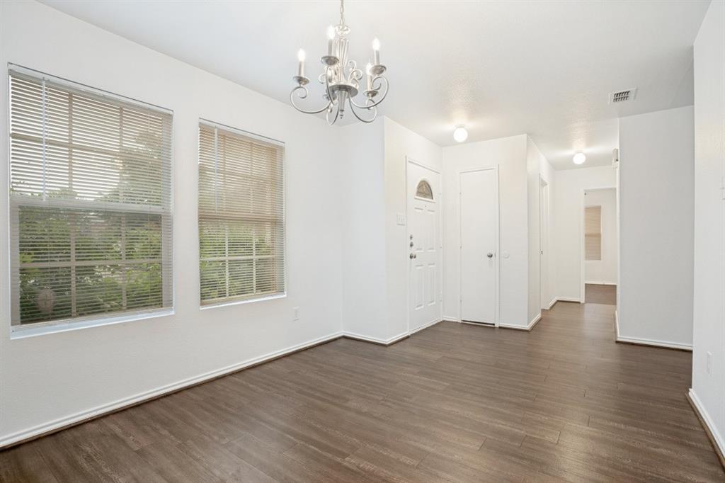 16701 Windthorst Way Fort Worth, TX 76247 - Photo 2 of 12 a view of an empty room with wooden floor and a window