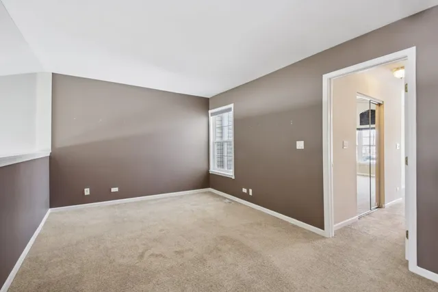 a view of an empty room with closet and wooden floor
