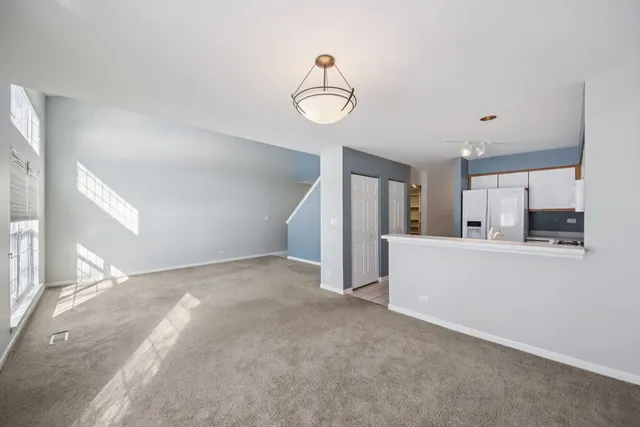 a view of a big room with chandelier fan and windows