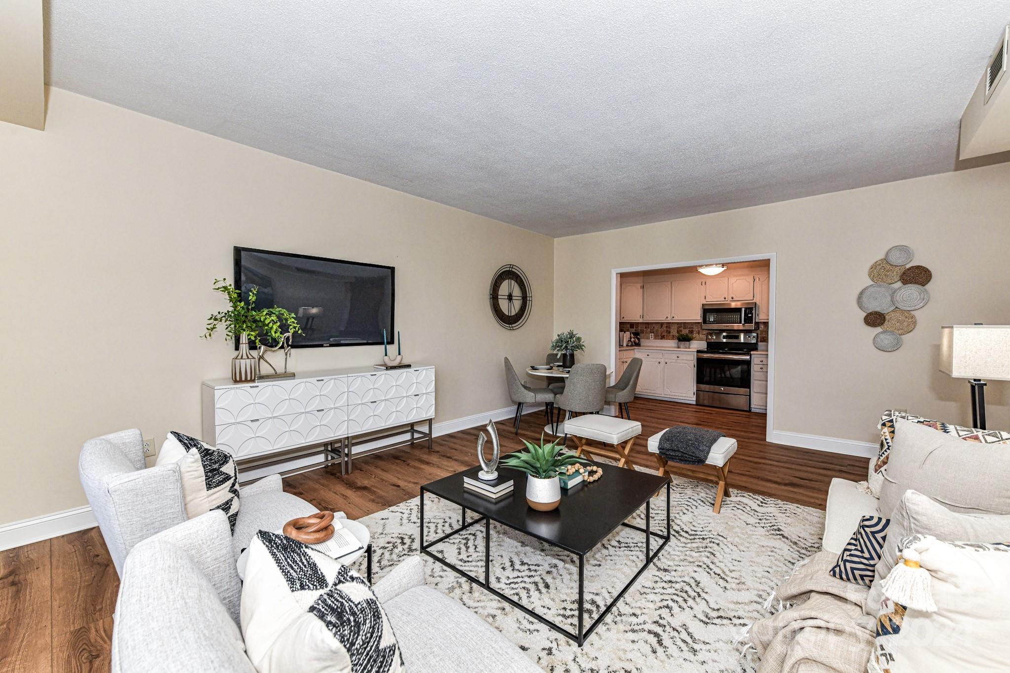 1300 Reece Road, Unit 415 Charlotte, NC 28209 - Photo 12 of 32 a living room with furniture and wooden floor